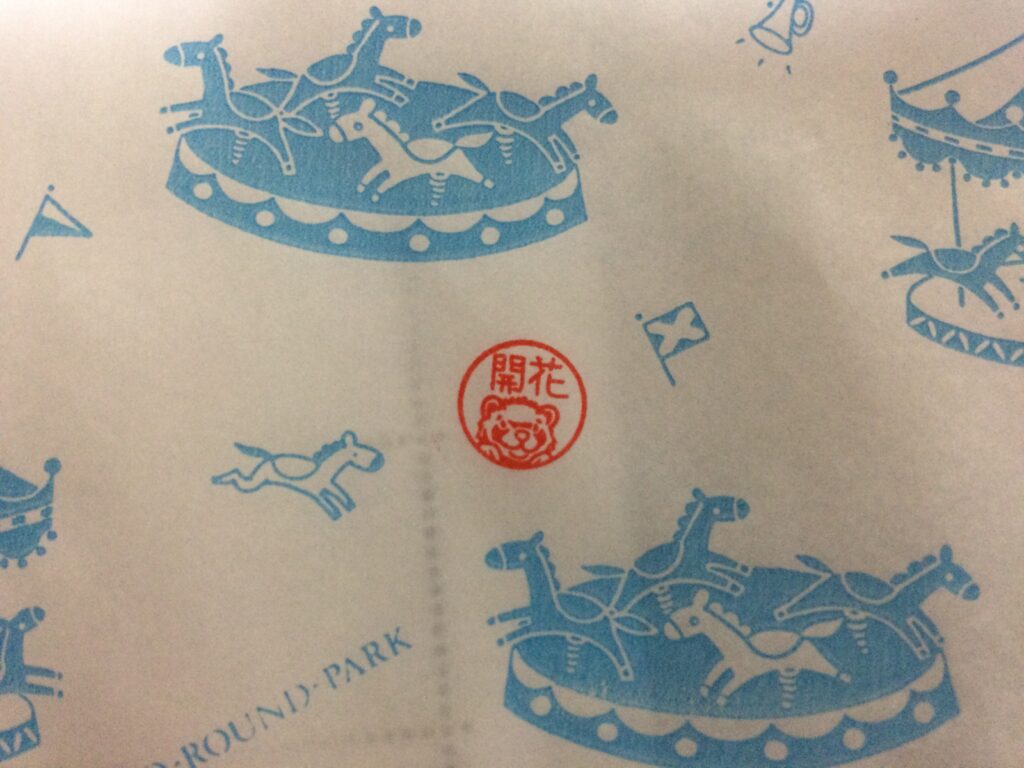 Hanko rouge avec le mot en kanji qui veut dire 'en fleurs'